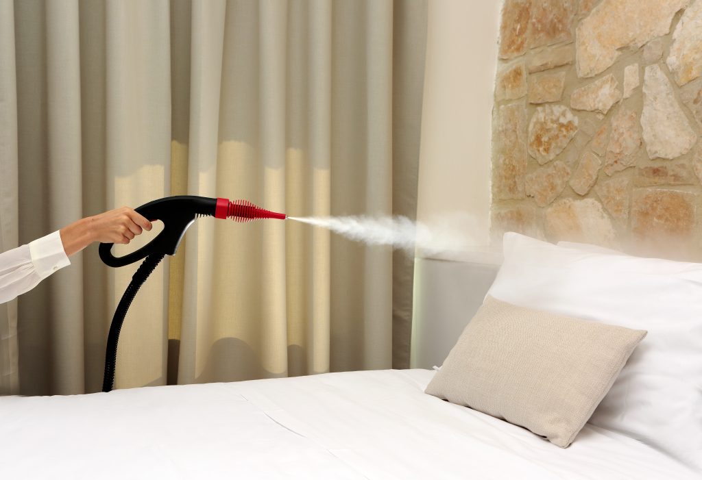 Nettoyage des chambres avec un nettoyeur vapeur professionnel Nettoyeur vapeur professionnel en action sur literie : désinfection d’un oreiller et d’un matelas, idéal pour éliminer bactéries, acariens et allergènes sans produits chimiques.
